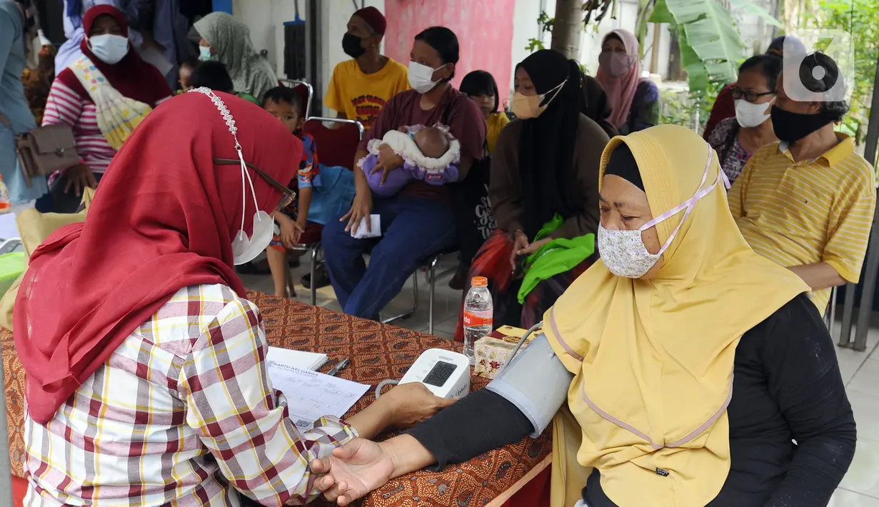 Warga menjalani pemeriksaan kesehatan saat melakukan vaksinasi booster COVID-19 di Balai RW 04, Ciganjur, Jakarta Selatan, Senin (18/7/2022). Pemerintah mulai memberlakukan kebijakan wajib vaksinasi ketiga atau booster COVID-19 sebagai syarat perjalanan dan masuk ke ruang publik mulai 17 Juli 2022. (merdeka.com/Arie Basuki)