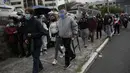Antrean panjang pensiunan yang menunggu disuntik vaksin Covid-19 di luar pusat vaksinasi Social Security Institute di Quito, Ekuador, Kamis (6/5/2021). Para lansia dan pendampingnya menunggu berjam-jam untuk divaksinasi. (AP Photo/Dolores Ochoa)