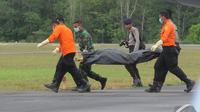  Petugas gabungan memindahkan kantong berisi jenazah penumpang AirAsia QZ8501,   Lanud Iskandar, Pangkalan Bun, Kalteng, Rabu (8/1/2015). (Liputan6.com/Herman   Zakharia)