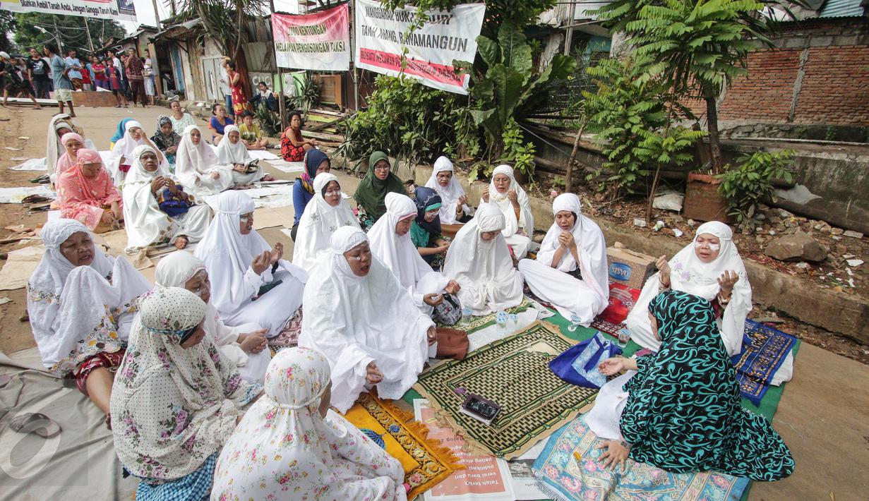 Sejumlah ibu-ibu menggelar doa bersama di lokasi, RT 1 RW 12, Jl Saharjo, Manggarai, Jakarta, Rabu (26/4). Penggusuran tersebut dilakukan untuk pembangunan Double Double Track (DDT) Manggarai-Soekarno Hatta. (Liputan6.com/Faizal Fanani)