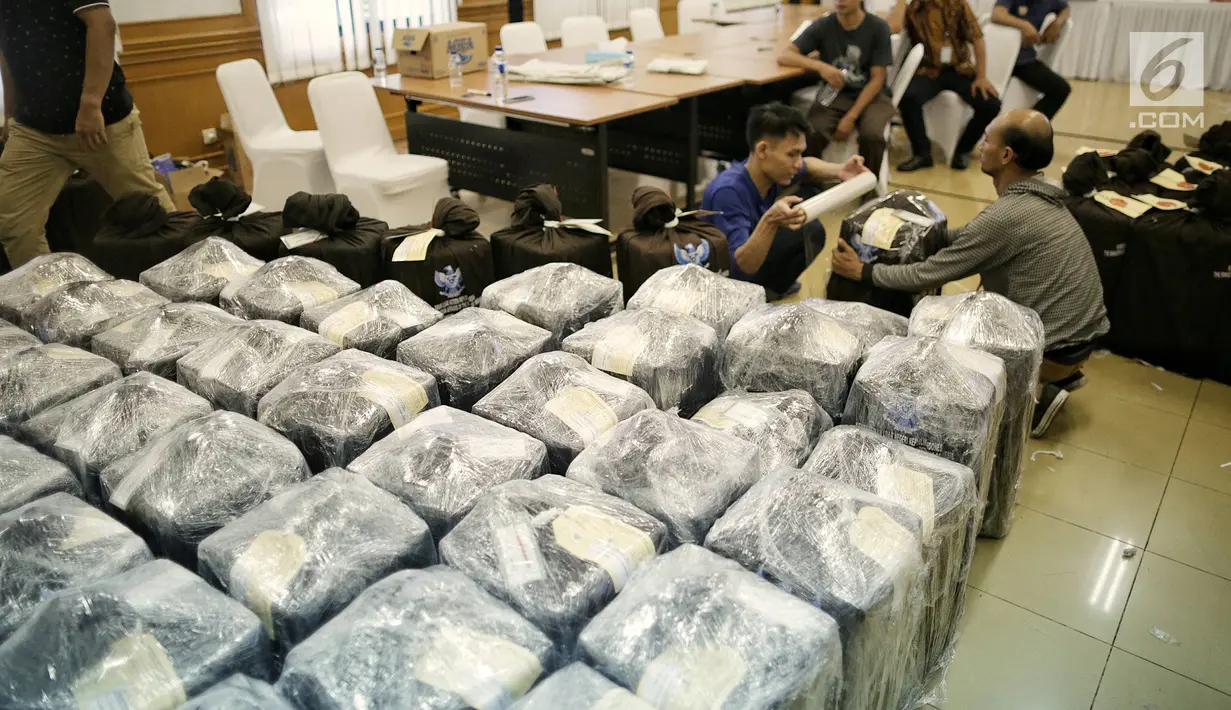Petugas membungkus plastik paket berisi surat suara Pemilu 2019 susulan di Gedung KPU RI, Jakarta, Minggu (28/4/2019). Surat suara susulan tersebut akan dikirimkan ke Kuala Lumpur, Malaysia untuk pelaksanaan pemilihan Presiden dan Wakil Presiden. (Liputan6.com/Faizal Fanani)