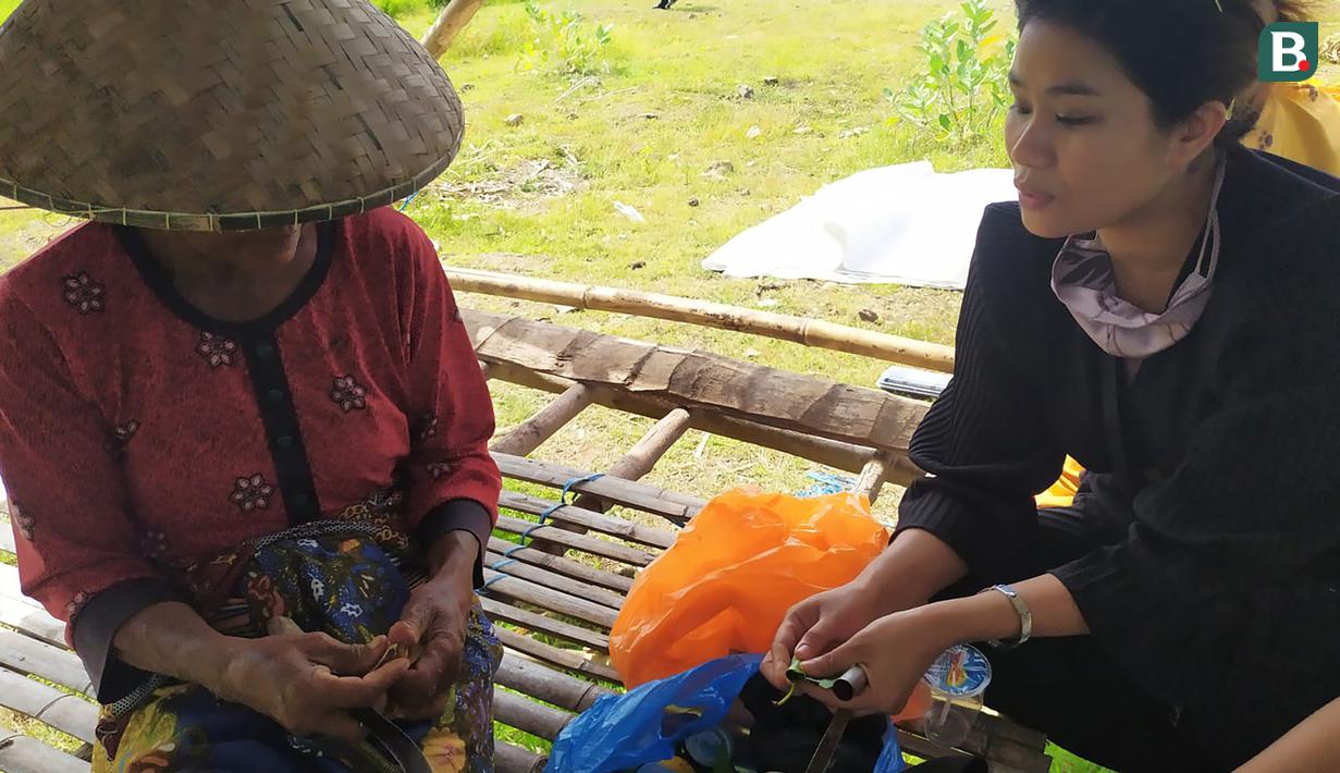 Warga mengunyah sirih sambil menunggu race MotoGP dimulai. (Bola.com/Wiwig Prayugi)