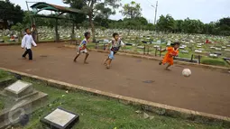 Anak-anak bermain bola di sekitar TPU Karet Bivak, Jakarta, Jumat (13/1). Semakin berkurangnya lahan hijau menyebabkan anak-anak di Ibukota terpaksa bermain di tempat yang tidak semestinya. (Liputan6.com/Immanuel Antonius)
