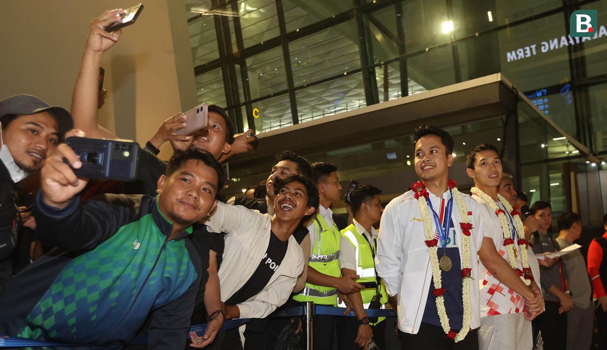 <p>Para fans melakukan swafoto dengan dua tunggal putra Indonesia, Anthony Ginting dan Jonatan Christie saat acara penyambutan para juara All England 2024 di Terminal 3 Bandara Soekarno Hatta, Tangerang, Banten, Senin (18/3/2024) malam WIB. (Bola.com/M Iqbal Ichsan)</p>