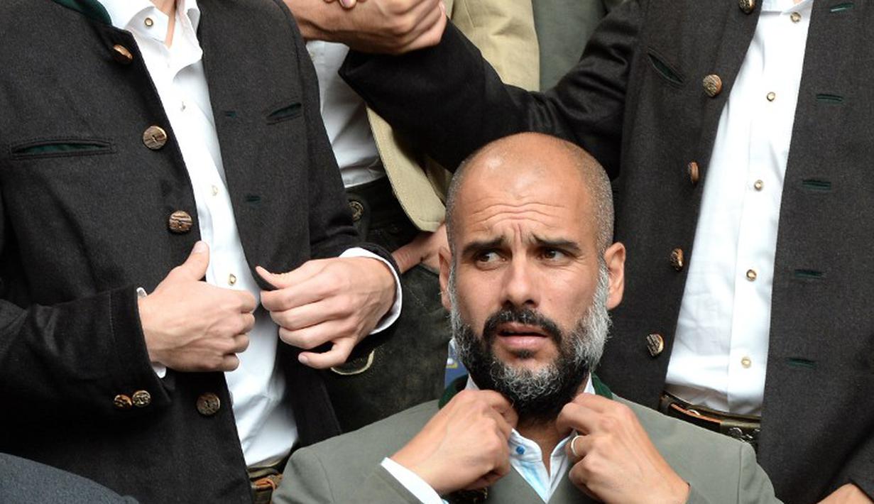 Pelatih Bayern Munchen, Pep Guardiola, pun terlihat antusias dengan sesi foto menggunakan kostum tradisional Bavaria. (AFP Photo/Christof Stache)