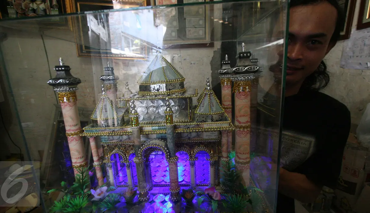 Seorang perajin, Albani, menunjukkan mahar pernikahan berbentuk miniatur masjid, di dusun Jotowang, Yogyakarta, Rabu (15/6). Pada Ramadan, pemesanan miniatur masjid berbahan dasar uang pecahan rupiah itu mengalami peningkatan. (Liputan6.com/Boy Harjanto)
