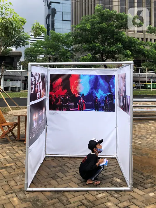 Komunitas “Kelas Jurnalis Cilik” dipandu pewarta foto mengikuti kegiatan tur pameran fotografi bertema 'Ragam Cerita Ibu Kota Sebelum dan Saat Pandemi COVID-19' di Thamrin 10, Jakarta, Minggu (6/12/2020). Pameran tersebut menampilkan 134 karya dari 89 pewarta foto. (Liputan6.com/Immanuel Antonius)