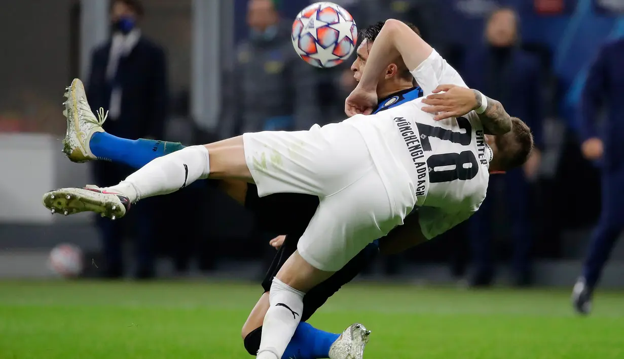 Bek Borussia Moenchengladbac, Matthias Ginter berebut bola dengan penyerang Inter Milan, Lautaro Martinez pada matchday pertama Grup B Liga Champions di Giuseppe Meazza, Kamis (22/10/2020) dini hari WIB. Inter Milan harus puas bermain imbang 2-2 saat menjamu Monchengladbach. (AP Photo/Luca Bruno)