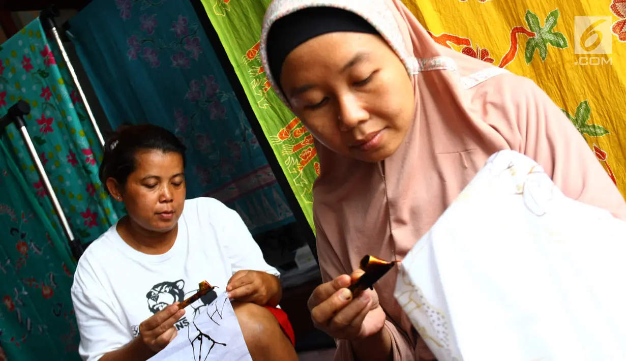 Perajin membuat pola batik bunga anggrek khas Tangerang Selatan pada kain di tempat pembuatan batik kawasan Pamulang, Minggu (21/10). Batik Tangsel ini sudah menembus pasar dunia seperti Makao, Kamboja, China, Hanoi dan Bangkok. (Merdeka.com/Arie Basuki)