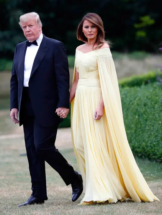 Presiden AS Donald Trump dan Melania Trump meninggalkan Winfield House di London, Kamis (12/7). Menghadiri acara makan malam, Melania terlihat begitu cantik dan anggun dalam balutan gaun panjang dengan 'cape' warna kuning. (AP/Pablo Martinez Monsivais)