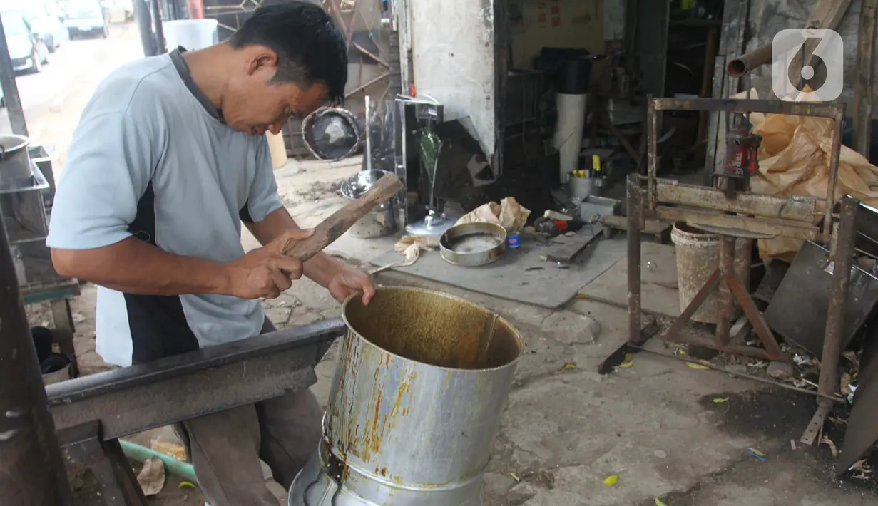 Seorang pengrajin membuat penanak nasi  di Pamulang, Tangerang Selatan, Banten  Minggu( 12/1/2020). Perabot tersebut dipasarkan hingga kawasan Jabotabek. (merdeka.com/Arie Basuki)