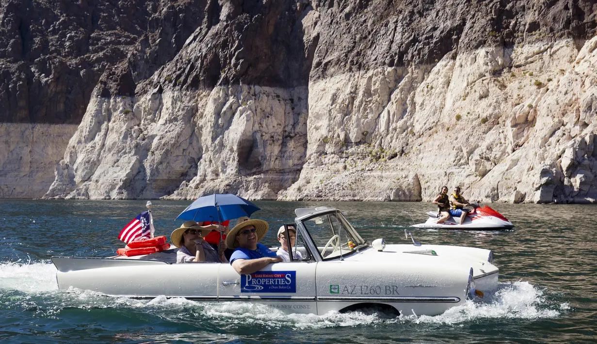 Keluarga Baker menaiki mobil amfibi Amphicar 1965 saat festival Las Vegas Amphicar Swim di Danau Mead, Nevada, Jumat (9/10). (REUTERS/Steve Marcus)