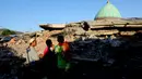 Warga melihat reruntuhan bangunan Masjid Jamiul Jamaah yang rusak akibat gempa bumi di Bangsal, Lombok Utara, Rabu (8/8). Berdasarkan kesaksian warga, diduga puluhan korban yang sedang melaksanakan pengajian tertimbun bangunan masjid. (AP/Tatan Syuflana)