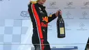 Pebalap Red Bull, Max Verstappen membawa trofi dan sampanye usai memenangkan F1 GP Austria di Red Bull Ring, Spielberg, Minggu (30/6/2019). Max Verstappen menggeser Sebastian Vettel dari peringkat ketiga klasemen F1. (ERWIN SCHERIAU/APA/AFP)