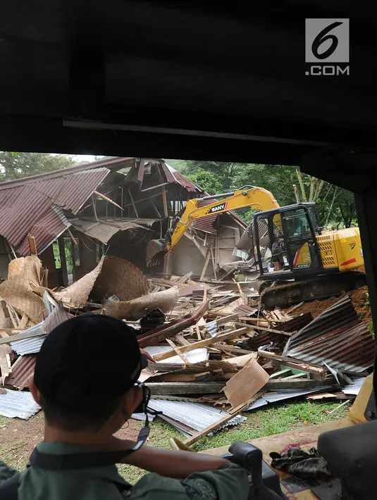 Petugas menggunakan alat berat membongkar bangunan vila ilegal di Kawasan Hutan Blok Cisadon, Bogor Selasa (24/4). Ini merupakan penertiban dan kegiatan penanaman kembali tanaman-tanaman di kawasan hutan blok Cisadon. (Merdeka.com/Arie Basuki)
