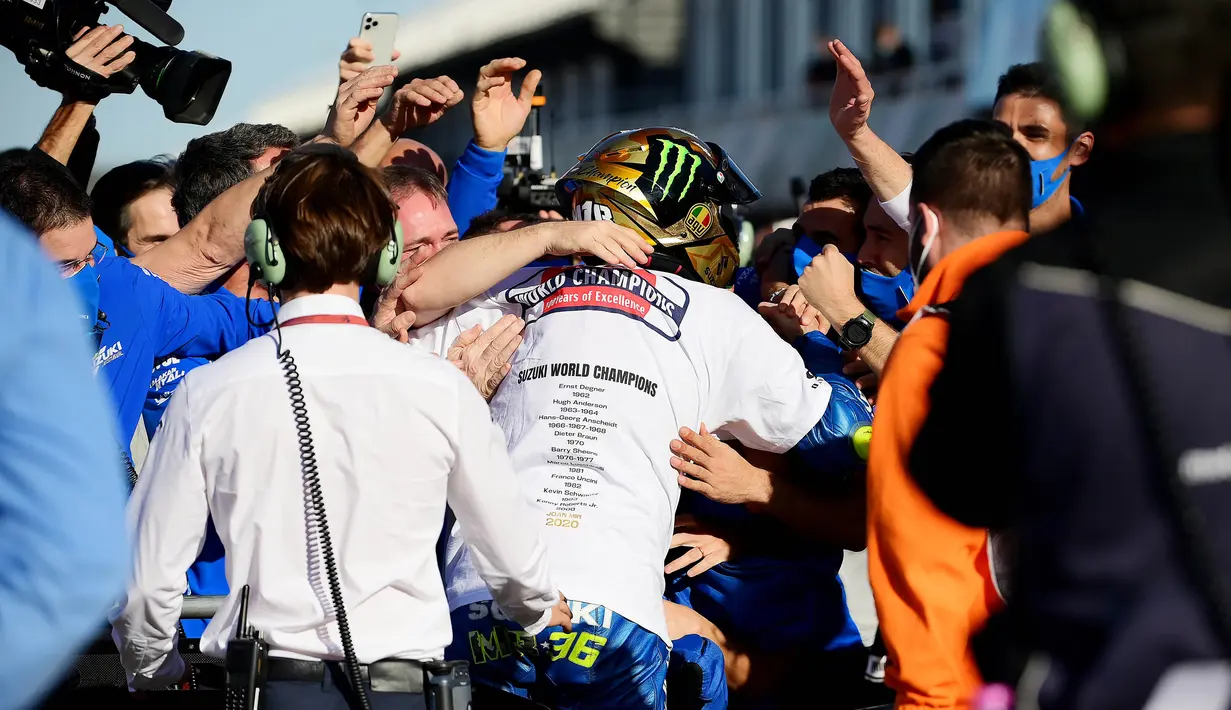 Tim Suzuki Esctar dan Joan Mir melakukan selebrasi usai balapan MotoGP Valencia di Sirkuit Ricardo Tormo, Minggu (15/11/2020). Meski finis ketujuh, Joan Mir berhasil mengunci gelar juara dunia MotoGP 2020. (AFP/Lluis Gene)