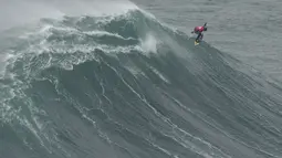 Peselancar Lucas Chianca melakukan putaran udara 360 saat keluar dari ombak selama kompetisi selancar ombak besar Nazare Tow Challenge di Praia do Norte, atau Pantai Utara, di Nazare, Portugal, Kamis, 10 Februari 2022. (AP Photo/Armando Franca)