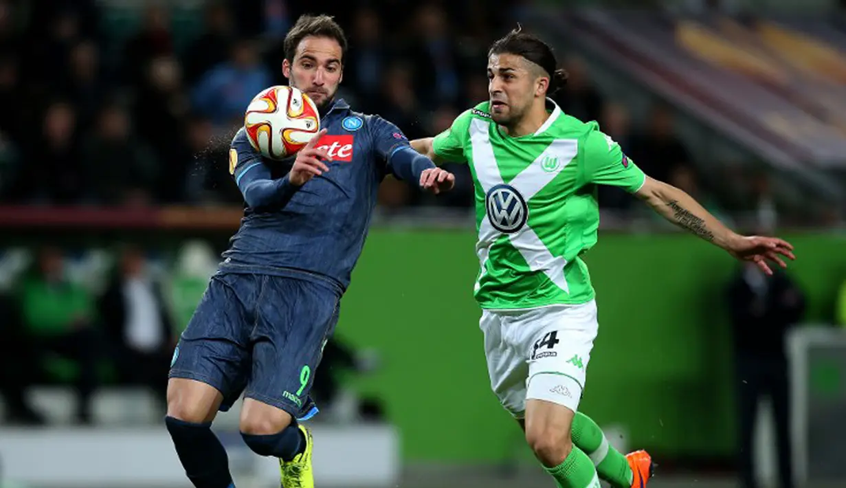 Penyerang Napoli, Gonzalo Higuain (kiri) mengontrol bola dari kejaran bek Wolfsburg Ricardo Rodriguez di leg pertama perempat final Liga Europa di Stadion Volkswagen Arena, Kamis (16/4/2015). Napoli menang 4-1 atas Wolfsburg.(AFP PHOTO/Ronny Hartmann)