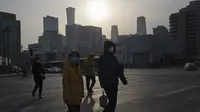 Warga yang memakai masker melintasi persimpangan di Beijing, China, Jumat (2/12/2022). Lebih banyak kota melonggarkan pembatasan, memungkinkan pusat perbelanjaan, supermarket, dan bisnis lainnya dibuka kembali menyusul protes akhir pekan lalu di Shanghai dan daerah lain di mana beberapa orang menyerukan Presiden Xi Jinping untuk mengundurkan diri. (AP Photo/Ng Han Guan)