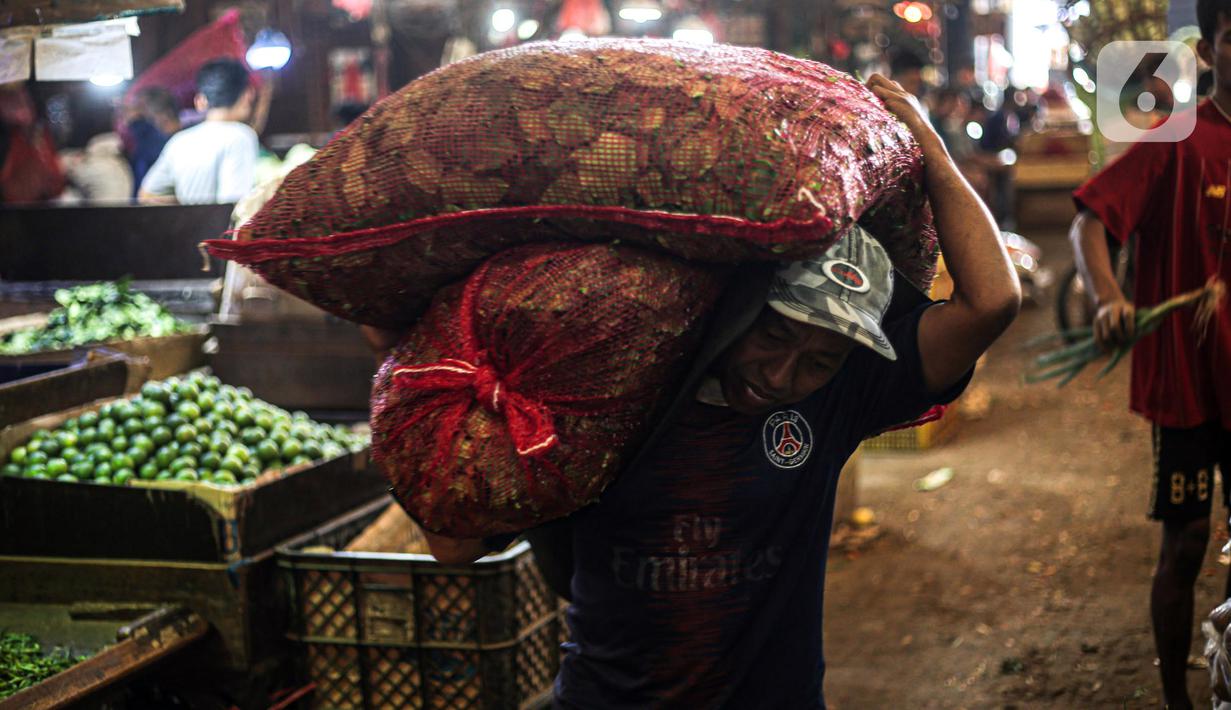 Pekerja memikul karung di Pasar Induk Kramat Jati, Jakarta, Kamis (29/12/2022). Rencananya, revitalisasi Pasar Kramat Jati ini akan selesai sekitar 18 bulan. (Liputan6.com/Faizal Fanani)
