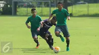 Dua pemain Timnas Indonesia U-22 berusaha menahan laju pemain Persita saat laga uji coba di Lapangan SPH Karawaci, Tangerang, Selasa (25/4). Timnas Indonesia U-22 unggul 2-1. (Liputan6.com/Helmi Fithriansyah)