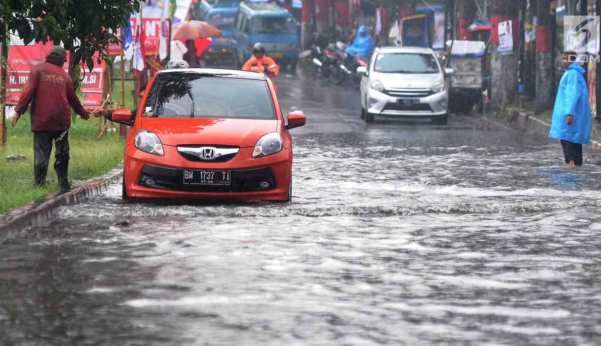 Pengendara bermotor melewati banjir di Jalan Cinere Raya (depan Mall Cinere), Depok, Jawa Barat, Minggu (31/3). Banjir menyebabkan kemacetan panjang di ruas jalan yang menghubungkan Lebak Bulus-Depok. (merdeka.com/Arie Basuki)