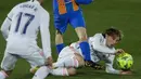 Gelandang Real Madrid, Luka Modric terjatuh saat berebut bola dengan penyerang Barcelona, Pedri pada pekan ke-30 Liga Spanyol di Estadio Alfredo Di Stefano, Minggu dinihari WIB (11/4/2021). Real Madrid kembali sukses taklukkan rival abadinya Barcelona 2-1. (AP Photo/Manu Fernandez)