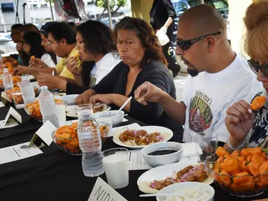 Peserta berlomba menyelesaikan makan cabai Habanero dalam Habanero Eating Contest di Restoran Chichen Itza, Los Angeles, Minggu (21/6). Dalam lomba ini setiap peserta diberikan 60 cabai Habanero dengan waktu 20 menit. (AFP PHOTO/Mark RALSTON)