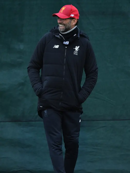 Pelatih Liverpool, Jurgen Kloop tersenyum saat melihat para pemainnya latihan Melwood Training Ground, Liverpool, Inggris (5/3). Pada leg pertama Liverpool unggul 5-0 di Markas Porto. (AFP Photo/Anthony Devlin)