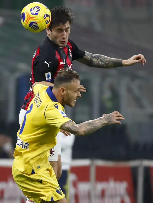 Bek AC Milan Davide Calabria dan bek Hellas Verona, Federico Dimarco melompat saat berebut bola pada lanjutan Liga Italia Serie A di San Siro, Senin (9/11/2020) dinihari WIB. AC Milan harus puas berbagi angka dengan Hellas Verona setelah bermain imbang 2-2. (AP Photo/Antonio Calanni)