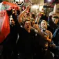 Pendukung Liverpool bernyanyi dan melambai-lambaikan bendera tim mereka di sebuah pub di alun-alun Campo de 'Fiori Roma, Italia (1/5). Liverpool akan menghadapi AS Roma di leg kedua semifinal Liga Champions. (AP Photo/Andrew Medichini )