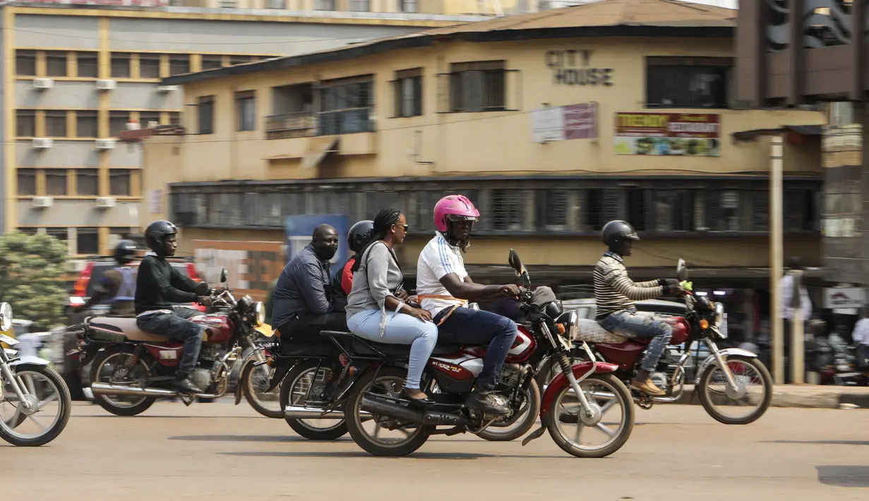 Pengemudi ojek, yang dikenal secara lokal sebagai boda-boda, berkendara bersama penumpang di jalan Kampala, Uganda, pada 18 Juli 2024. (AP Photo/Hajarah Nalwadda)