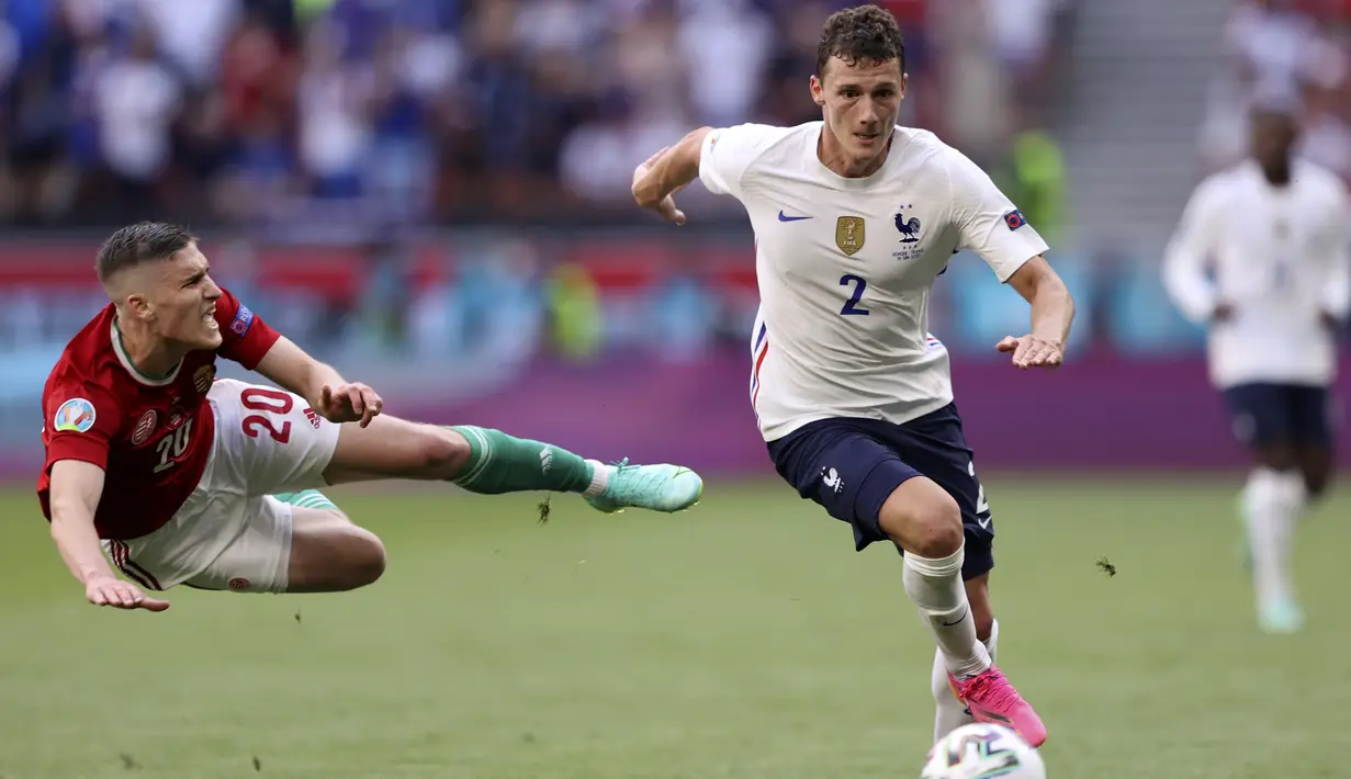 Gelandang Hungaria, Roland Sallai terlempar saat berusaha merebut bola dari bek Prancis, Benjamin Pavard pada pertandingan grup F Euro 2020 di stadion Ferenc Puskas di Budapest, Hungaria, Sabtu (19/6/2021). Prancis bermain imbang atas Hungaria 1-1. (Alex Pantling, Pool via AP)