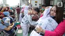 Sejumlah anak memeluk ibunya pada aksi cuci kaki ibu massal di Jakarta, Minggu (18/12/2022). Aksi yang diikuti sebanyak ratusann peserta itu bertujuan untuk meningkatkan rasa cinta kasih kepada ibu , khususnya dalam rangka memperingati Hari Ibu. (Liputan6.com/Faizal Fanani)