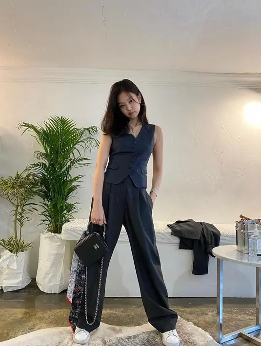 Jennie BLACKPINK tampil dengan menggunakan suit vest dan wide leg pants warna selaras. Gaya smart casualnya pun diperlengkap dengan sneakers. (Instagram/jennierubyjane).