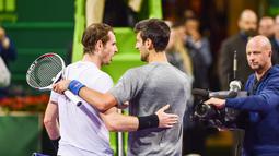 Petenis Serbia, Novak Djokovic dan petenis Skotlandia, Andy Murray saling berangkulan usai final turnamen Qatar Terbuka di Doha, Sabtu (7/1). Djokovic berhasil meraih gelar Qatar Open 2017 dengan skor 6-3, 5-7, 6-4. (AP Photo/Alexandra Panagiotidou)