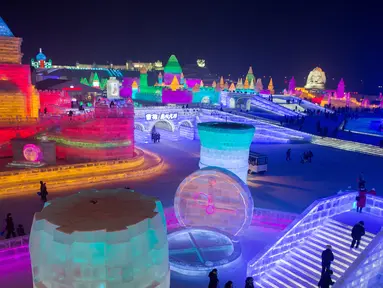 Suasana saat Festival Es dan Salju digelar di Harbin, Tiongkok, Rabu (4/1). Festival musim dingin legendaris tersebut kembali menampilkan pahatan dan replika sejumlah ikon dunia berukuran raksasa yang terbuat dari es.( AFP PHOTO / Nicolas ASFOURI)