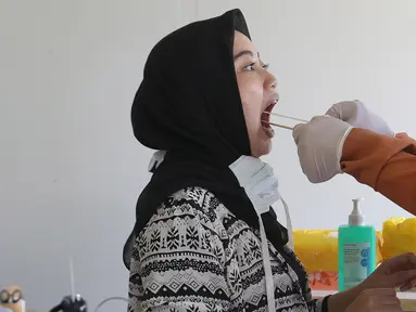 Petugas medis melakukan swab test terhadap warga di Rumah Sakit Universitas Indonesia (RSUI), Depok, Jawa Barat, Selasa (2/6/2020). RSUI menggelar program pekan swab test massal mulai tanggal 2-19 Juni 2020. (Liputan6.com/Herman Zakharia)