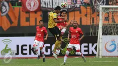 Pemain Persija Jakarta berebut bola di udara dengan pemain Barito Putera saat pertadingan Liga 1 di Stadion Patriot, Bekasi (22/4). Skor pada pertandingan antar Persija Jakarta kontra Barito Putera tersebut 1-1. (Liputan6.com/Gempur M. Surya)