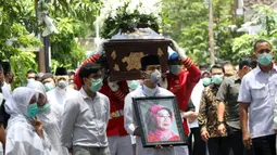 Putra Presiden Joko Widodo atau Jokowi, Gibran Rakabuming Raka (tengah) membawa foto sang nenek Sudjiatmi Notomihardjo saat akan disalatkan di masjid dekat kediamannya di Solo, Jawa Tengah, Kamis (26/3/2020). Sujiatmi Notomiharjo wafat di RST Slamet Riyadi, Solo. (Liputan6.com/Fajar Abrori)