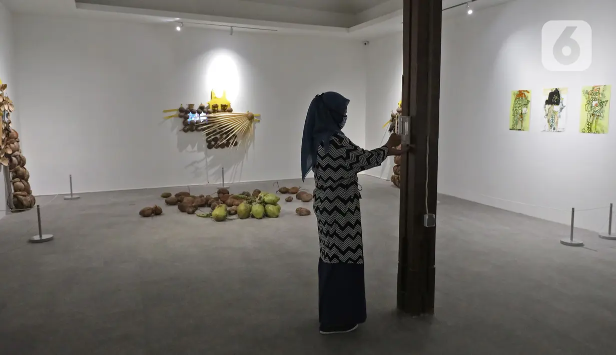 Pengunjung melihat karya yang dipajang dalam pameran Pulih di Pasar Seni, Ancol, Jakarta, Sabtu (14/11/20). Sebanyak 10 seniman Indonesia digandeng untuk pameran yang dibuka pada 14 sampai 29 November 2020 mendatang tersebut. (Liputan6.com/Herman Zakharia)