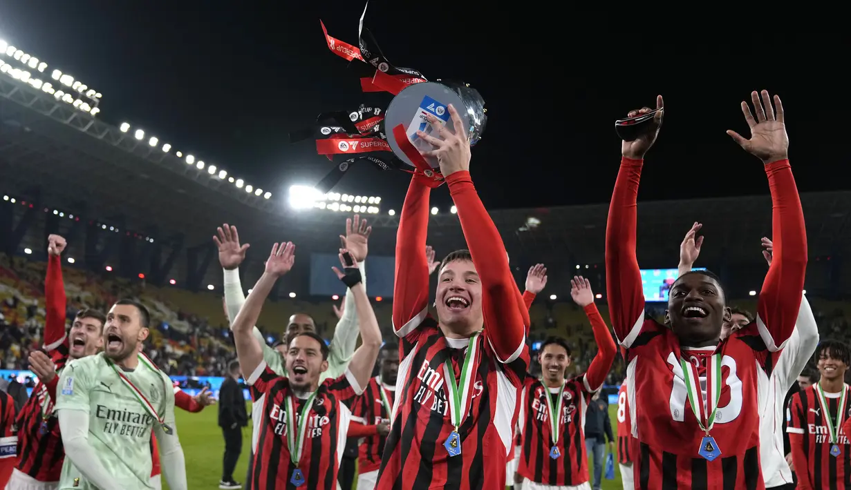 Sejumlah pemain AC Milan merayakan juara Piala Super Italia 2024/2025 setelah mengalahkan Inter Milan pada laga final yang berlangsung di Al-Awwal Park, Riyadh, Arab Saudi, Senin (06/01/2025) waktu setempat. (AFP/Fayez Nureldine)