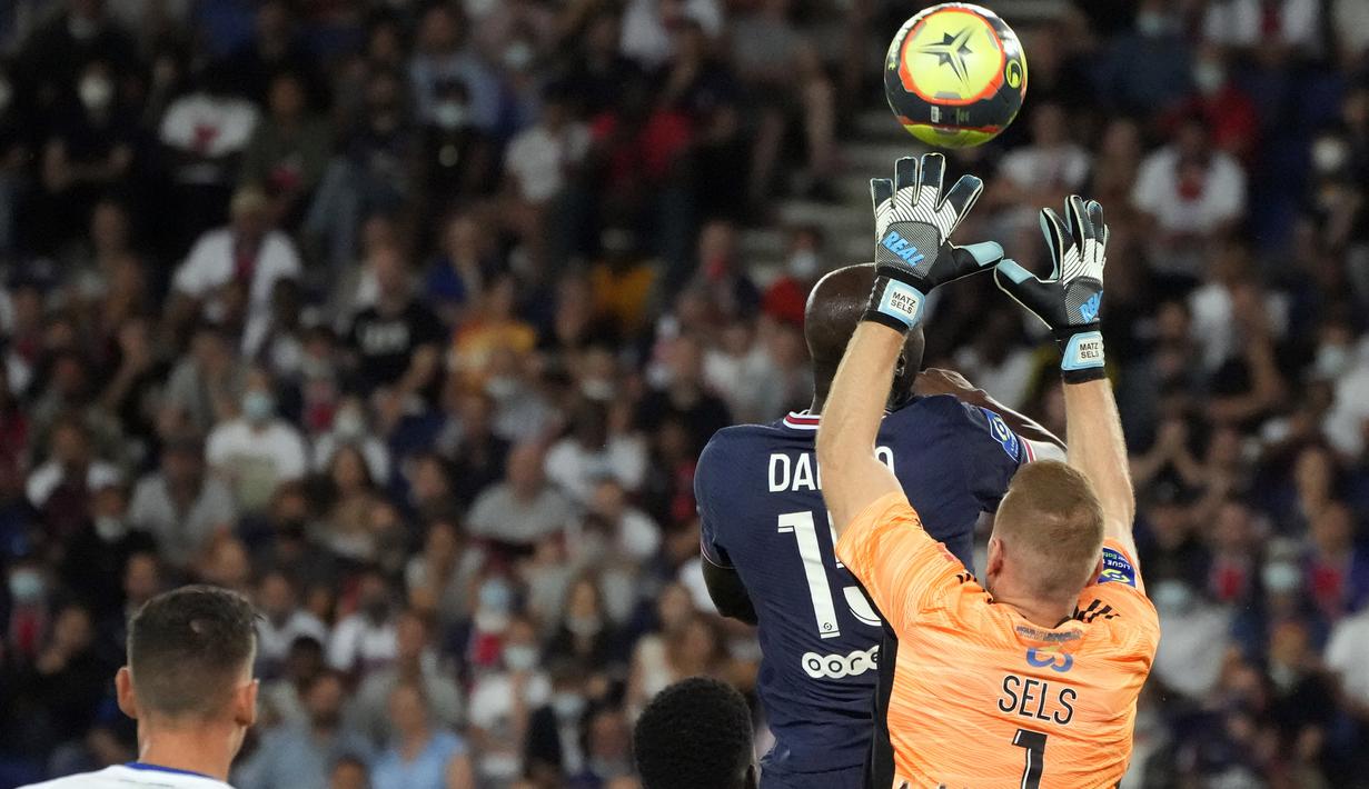 Kiper Strasbourg Matz Sels melakukan penyelamatan di depan gelandang Paris Saint-Germain (PSG) Danilo Pereira pada laga pekan kedua Liga Prancis di Stadion Parc des Princes, Minggu (15/8/2021) dini hari WIB. PSG membekuk tamunya Strasbourg dengan skor 4-2. (AP Photo/Francois Mori)