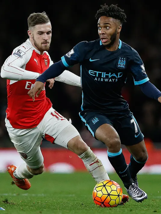 Gelandang Manchester City, Raheem Sterling (kanan) berusaha membawa bola dari kejaran gelandang Arsenal, Aaron Ramsey pada lanjutan liga Inggris di Stadion Emirates (21/12). Arsenal menang atas City dengan skor 2-1. (AFP PHOTO/ADRIAN DENNIS)