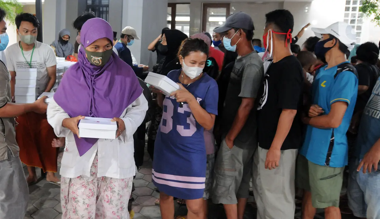 Warga menerima makanan berbuka puasa atau takjil di Masjid Wihdatul Ummah, Cinere, Depok, Jawa Barat, Kamis (7/4/2022). Dalam sehari, Masjid Wihdatul Ummah menyediakan lebih dari 700 takjil berupa nasi kotak yang merupakan sumbangan donatur jemaah masjid. (merdeka.com/Arie Basuki)