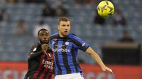 Penyerang Inter Milan Edin Dzeko dan bek AC Milan AC Milan Fikayo Tomori melihat ke arah bola dalam pertandingan final Piala Super Italia 2022 di King Fahd International Stadium, Riyadh, Arab Saudi, Kamis (19/1/2023) dini hari WIB. Dalam laga tersebut, Nerrazurri tanpa diperkuat Marcelo Brozovic dan Samir Handanovic. (AP Photo/Hussein Malla)