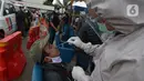 Petugas medis mengambil sampel lendir seorang pria untuk tes usap atau Swab Antigen di Pelabuhan Kali Adem, Jakarta, Kamis (31/12/2020). Pemeriksaan swab antigen wisatawan yang akan libur Tahun Baru di Kepulauan Seribu dilakukan untuk mencegah penyebaran COVID-19. (merdeka.com/Imam Buhori)