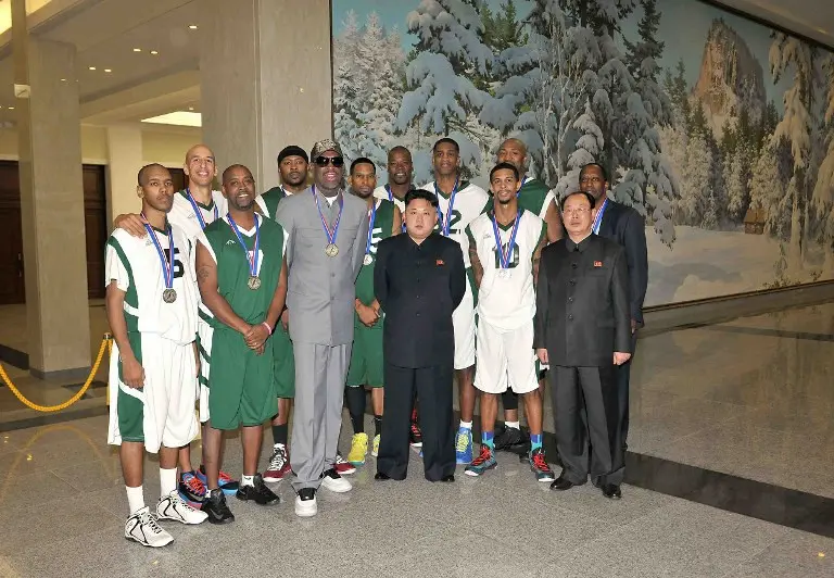 Foto diambil pada 8 Januari 2014 dan dirilis oleh Korean Central News Agency (KCNA)pada  January 9, 2014, memperlihatkan Kim Jong-un foto bersama mantan bintang NBA Dennis Rodman bersama mantan pemain NBA lainnya di Pyongyang Gymnasium  Pyongyang.  (KCNA/