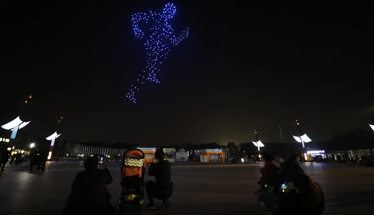 Sejumlah orang menikmati pertunjukan cahaya di Taman Olimpiade di Seoul, Korea Selatan. Sebuah pertunjukan cahaya yang menampilkan 315 drone digelar di Seoul pada Jumat (13/11). (Xinhua / Kementerian Agraria, Infrastruktur, dan Transportasi Korea Selatan)