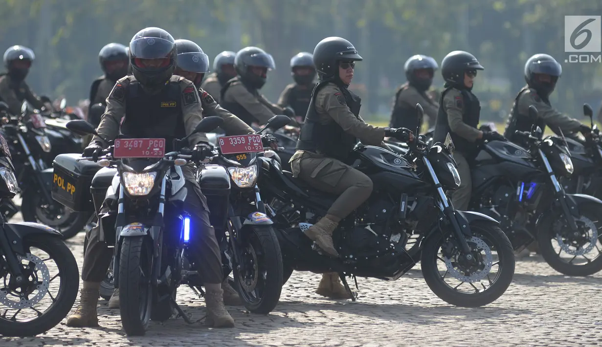Satuan Polisi Pamong Praja (Satpol PP) mengikuti upacara peringatan HUT ke-69 Satpol PP dan ke-57 Satuan Perlindungan Masyarakat (Satlinmas) di Lapangan Monas, Jakarta, Rabu (7/8/2019). Dalam peringatan itu, Gubernur DKI Anies Baswedan bertindak menjadi inspektur upacara. (merdeka.com/Imam Buhori)